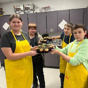 Students showing their baked goods in home economics class.