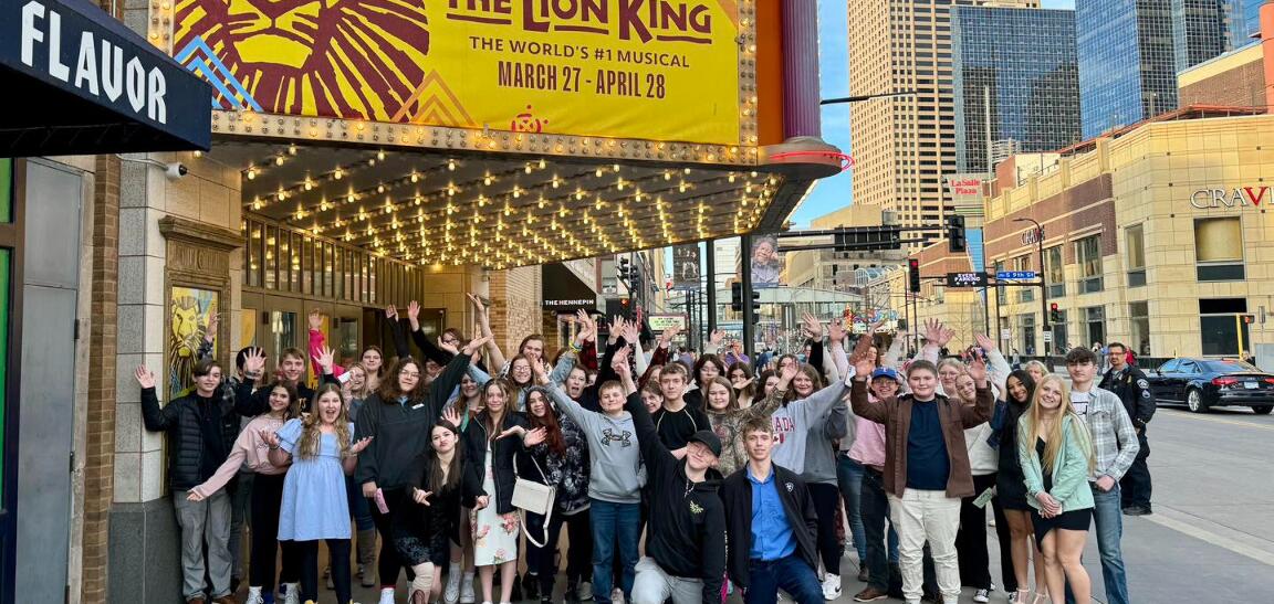 Students pose outside The Orpheum in Minneapolis before a performance of The Lion King.